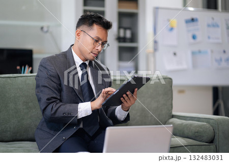 Businessman using laptop computer in office. Happy man, entrepreneur, small business owner working online. Businessman using laptop computer in office. Happy man, entrepreneur, small business owner working online. 132483031