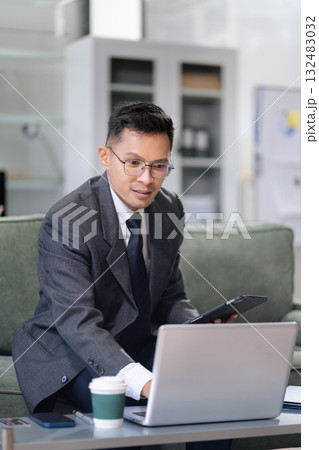 Businessman using laptop computer in office. Happy man, entrepreneur, small business owner working online. Businessman using laptop computer in office. Happy man, entrepreneur, small business owner working online. 132483032