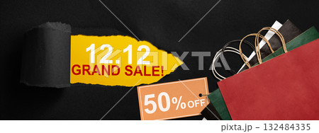 Top view of black ripped paper and text of 12.12 grand sale with up to 50% text on the label tag. Copy space. Flash sale concept 132484335