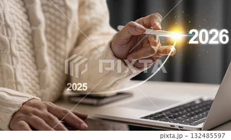 Female hand with laptop and cellphone slides the ascending line from 2025 to 2026 on a virtual screen. Happy New Year concept or Celebration Female hand with laptop and cellphone slides the ascending line from 2025 to 2026 on a virtual screen. Happy New Year concept or Celebration 132485597