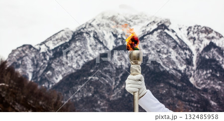 Olympic flame burning bright in winter mountains 132485958