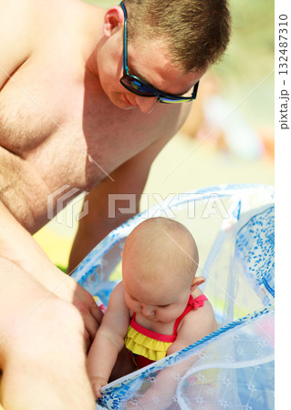 Man playing with little baby on beach Man playing with little baby on beach 132487310