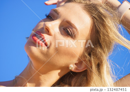 Face of young woman in sunlight Face of young woman in sunlight 132487451