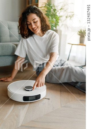 White robotic vacuum cleaner on wooden floor White robotic vacuum cleaner on wooden floor 132487491