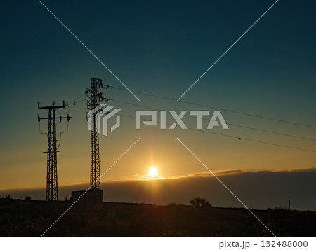 High voltage towers on coast at sunset 132488000