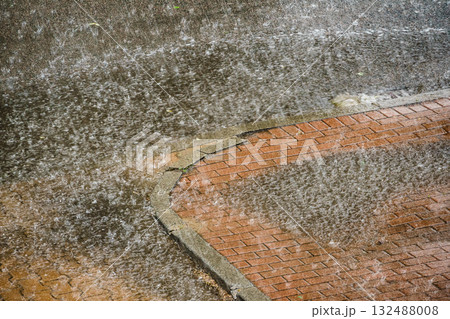 Heavy rain drops falling on city street. 132488008