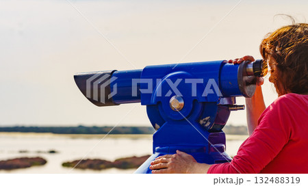 Woman using tourist binoculars, Cabo de Gata, Spain 132488319