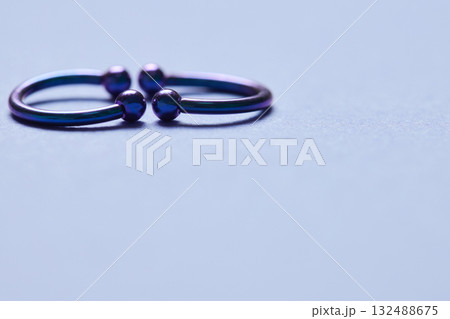 Piercing earrings close-up. On a black background. 132488675