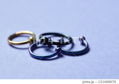 Piercing earrings close-up. On a black background. 132488678