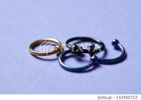 Piercing earrings close-up. On a black background. 132488722