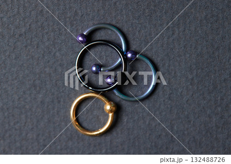 Piercing earrings close-up. On a black background. 132488726