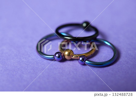 Piercing earrings close-up. On a black background. 132488728