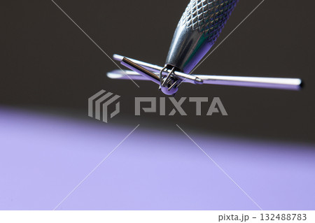 Piercing earrings close-up. On a Violet background. Piercing earrings close-up. On a Violet background. 132488783