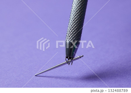 Piercing earrings close-up. On a Violet background. 132488789