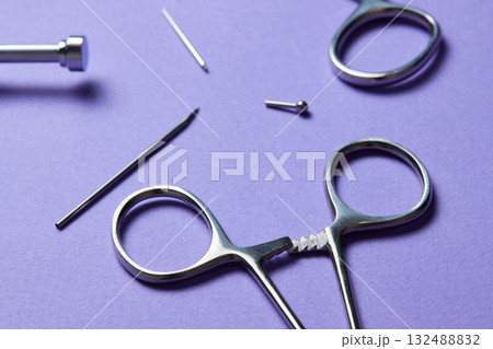 Piercing earrings close-up. On a Violet background. 132488832