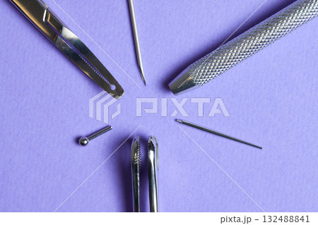 Piercing earrings close-up. On a Violet background. Piercing earrings close-up. On a Violet background. 132488841