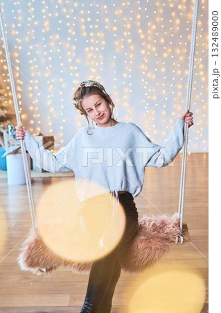 fragile teenage girl surrounded by Christmas lights 132489000