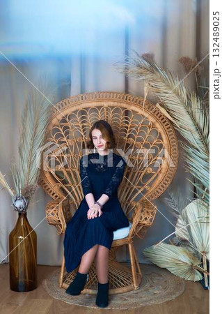 teenage girl in a dress in a romantic location with dry reed stalks 132489025