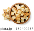 Bread croutons in a wooden plate and scattered close-up on a white. Top view 132490237