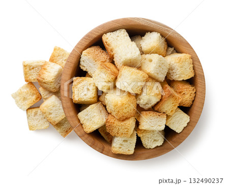 Bread croutons in a wooden plate and scattered close-up on a white. Top view Bread croutons in a wooden plate and scattered close-up on a white. Top view 132490237