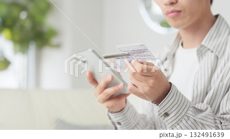 マイナ保険証を設定するアジア人男性 132491639