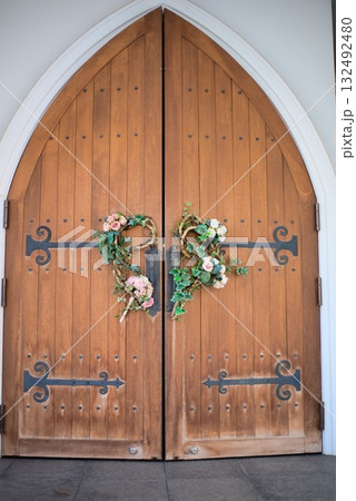 木製アーチ扉に飾られたフラワーリースのウェディングドア 132492480