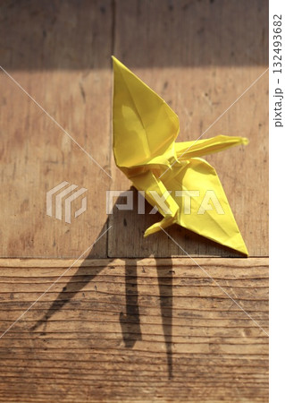 子供が作った少しいびつな黄色の折鶴 子供が作った少しいびつな黄色の折鶴 132493682
