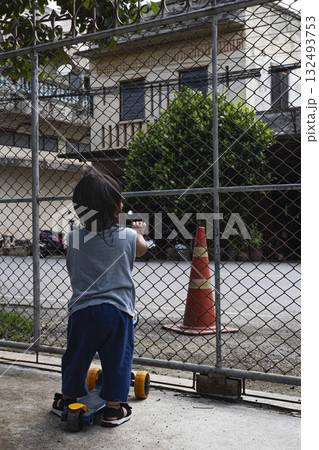 Curious Toddler Grabbing Fence Bars, A curious toddler grips fence bars, tiny hands exploring safely at home, the secure play, perfect for family safety photo or child home protection. 132493753