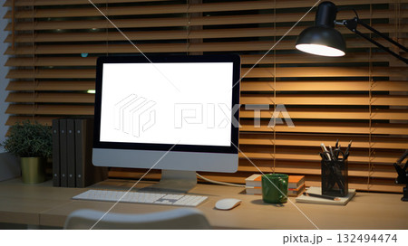 Computer on desk in peaceful nighttime workspace with office supplies Computer on desk in peaceful nighttime workspace with office supplies 132494474