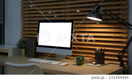 Computer on desk in peaceful nighttime workspace with office supplies 132494494