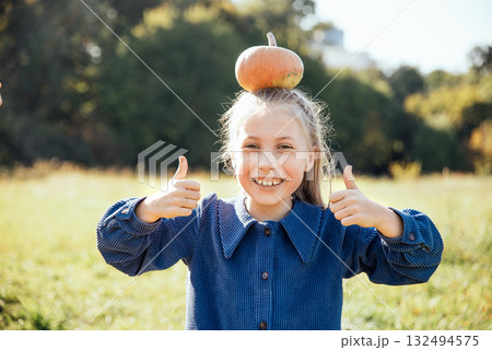 Autumn harvest organic pumpkins and apples. Happy girl on pumpkin patch on cold autumn day, with lot of pumpkins for halloween or thanksgiving Children on pumpkin field. Autumn harvest organic pumpkins and apples. Happy girl on pumpkin patch on cold autumn day, with lot of pumpkins for halloween or thanksgiving Children on pumpkin field. 132494575