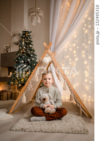 Child Enjoying Christmas by the Cozy Tent with Teddy Child Enjoying Christmas by the Cozy Tent with Teddy 132495310