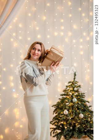 Woman Holding Gift Boxes by Christmas Tree Woman Holding Gift Boxes by Christmas Tree 132495323