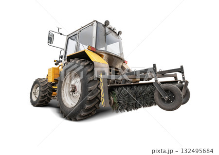 A tractor equipped with a large sweeper brush against an isolated background. Cleaning city roads of dust and debris. Equipment rental. A tractor equipped with a large sweeper brush against an isolated background. Cleaning city roads of dust and debris. Equipment rental. 132495684