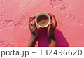 Female hands holding a cup of coffee in the pink background. African woman's hands with a cappuccino mug aerial view. 132496620