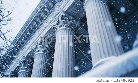 Snow falls softly on the grand columns of a historic building in a winter landscape 132496922