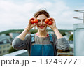 A woman is holding two tomatoes in her hands and smiling 132497271