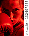 A woman wearing a red boxing glove is shown in a close up 132497285