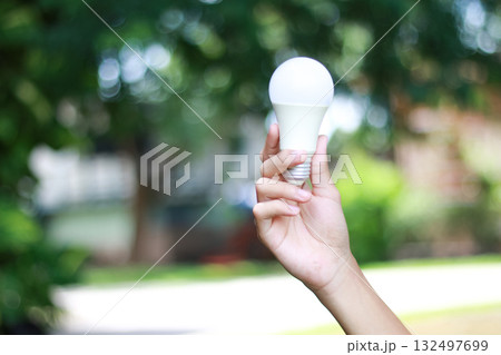 Human hand holding glowing light bulb symbolizing inspiration 132497699