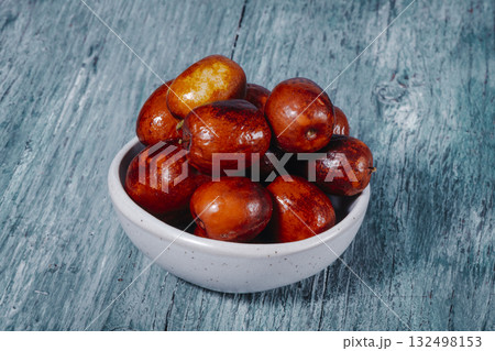 bowl filled with glossy jujube fruits 132498153