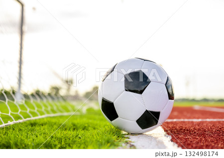 Footballs on the field and goal nets in a large stadium Footballs on the field and goal nets in a large stadium 132498174
