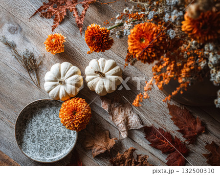 White pumpkins and vibrant flowers create a cozy autumn vibe with natural textures and warm colors White pumpkins and vibrant flowers create a cozy autumn vibe with natural textures and warm colors 132500310