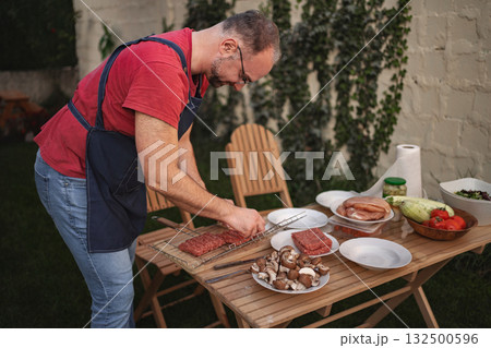 Preparing a delicious barbecue feast in a cozy backyard setting Preparing a delicious barbecue feast in a cozy backyard setting 132500596