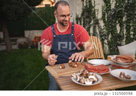 Enthusiastic cook prepares fresh ingredients in a sunny backyard setting Enthusiastic cook prepares fresh ingredients in a sunny backyard setting 132500598