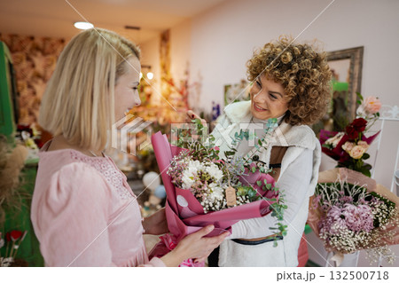 Joyful exchange of a beautiful bouquet in a charming flower shop Joyful exchange of a beautiful bouquet in a charming flower shop 132500718