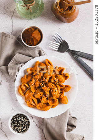 Delicious shell pasta with miso paste on a plate on the table top and vertical view 132501379