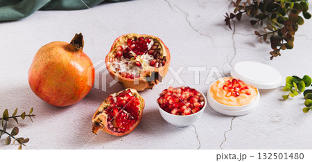 Pomegranate skin care cream in a jar and fruit on the table web banner Pomegranate skin care cream in a jar and fruit on the table web banner 132501480