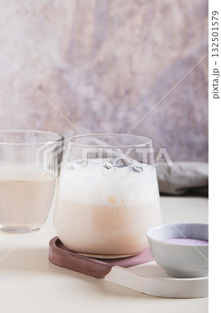 Cloudy pink matcha with coconut water in a glass on the table vertical view Cloudy pink matcha with coconut water in a glass on the table vertical view 132501579