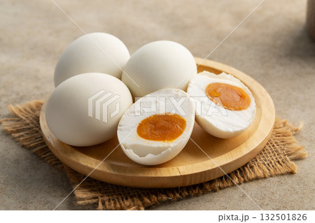 Salted eggs in wooden plate.a preserved food, traditionally made by curing duck or chicken eggs in brine.popular delicacy in many Asian cuisines. Salted eggs in wooden plate.a preserved food, traditionally made by curing duck or chicken eggs in brine.popular delicacy in many Asian cuisines. 132501826