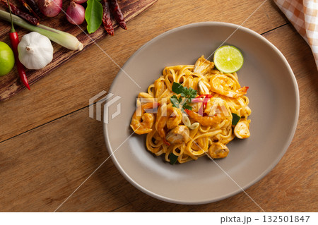 Creamy Fettuccine pasta Tom Yum Kung,Thai style fusion food, spicy spaghetti with shrimp and straw mushroom in tom yum sauce.Top view. Creamy Fettuccine pasta Tom Yum Kung,Thai style fusion food, spicy spaghetti with shrimp and straw mushroom in tom yum sauce.Top view. 132501847
